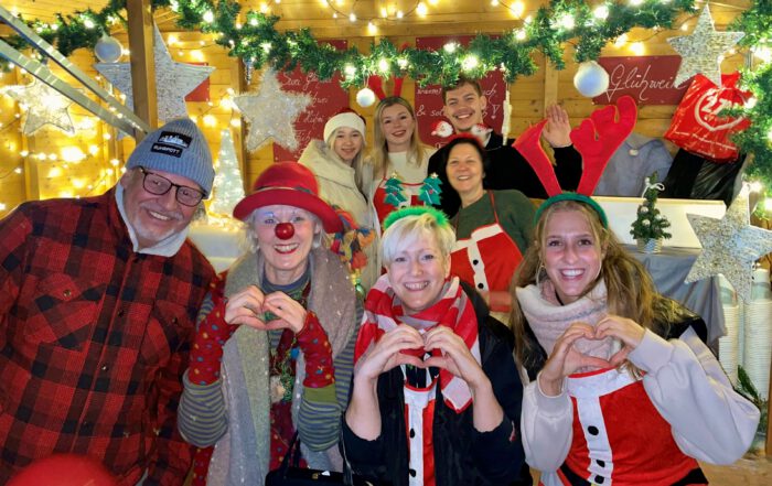Gruppe auf dem Adventsmarkt, mit einer Clownin